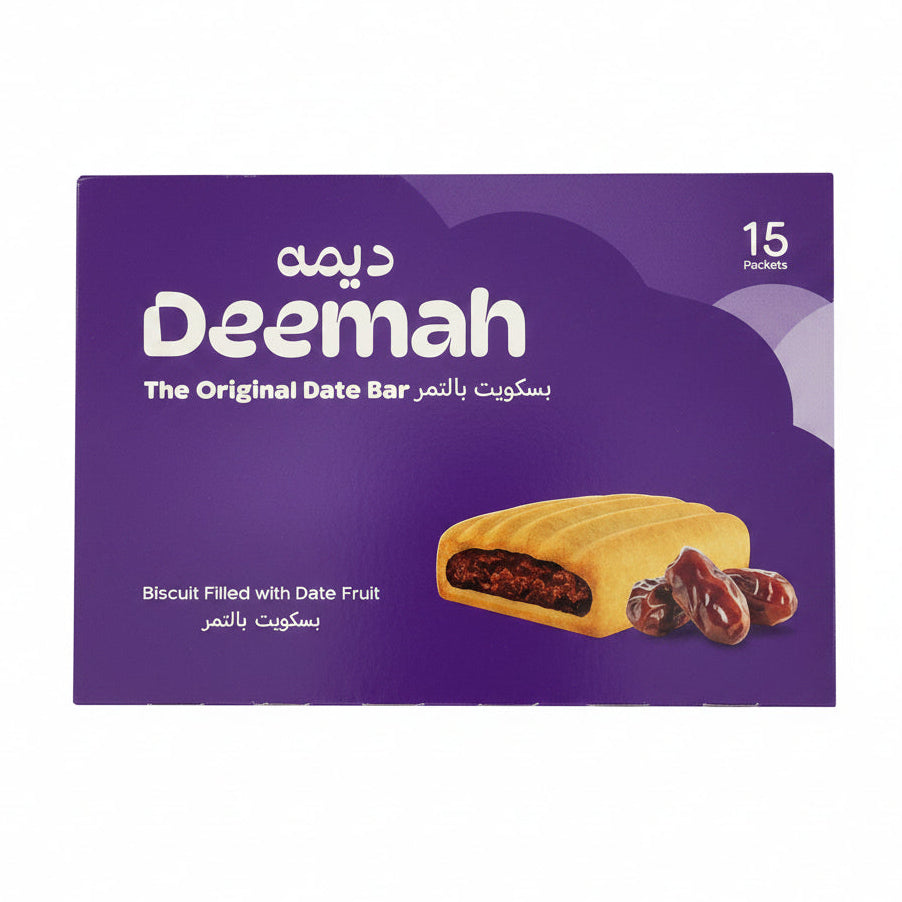 A package of Deemah date bars wrapped in clear plastic, showing a purple box with the brand name 'Deemah' and an image of a biscuit filled with date fruit, placed on top of other packaged goods.