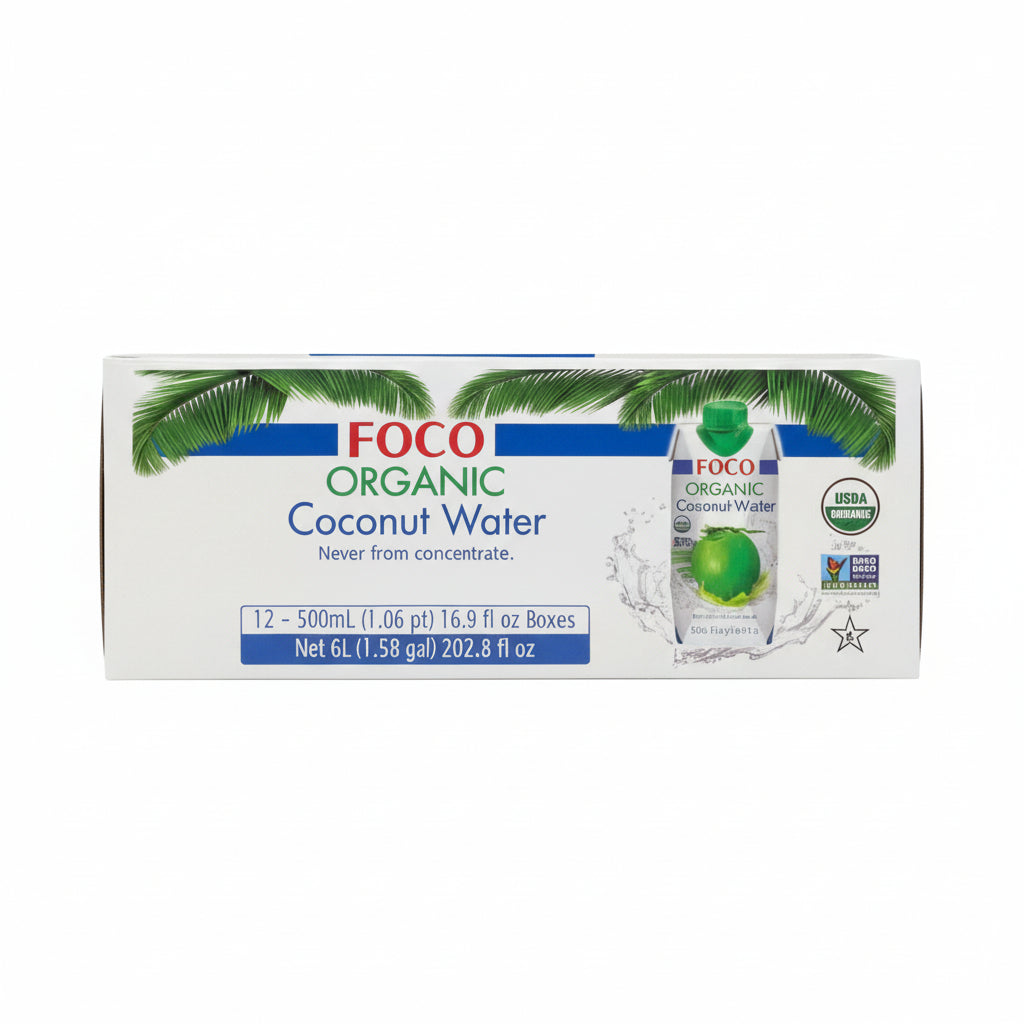 FOCO Organic Coconut Water in a 12-count box stacked on warehouse shelves. The white packaging features green palm leaves, blue bands, and a bottle graphic showing the coconut water with a green coconut inside.